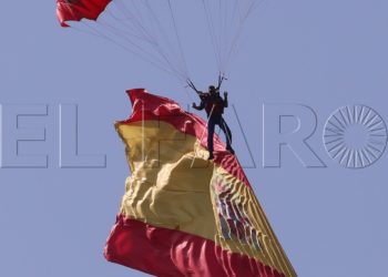 GRA096. MADRID, 12/10/2017.- Un paracaidista con una bandera de España desciende hasta el asfalto del Paseo de la Castellana al inicio del desfile del Día de la Fiesta Nacional que ha sido presidido hoy por los Reyes, y al que ha asistido el Gobierno en pleno, encabezado por Mariano Rajoy, y la mayoría de líderes políticos. El acto consiste en un homenaje a los caídos y un desfile terrestre y aéreo por el paseo de la Castellana, en el que participan unos 3.900 efectivos, entre militares de los tres Ejércitos, guardias civiles, policías y Guardia Real, 84 vehículos y 78 aeronaves. EFE/Kiko Huesca