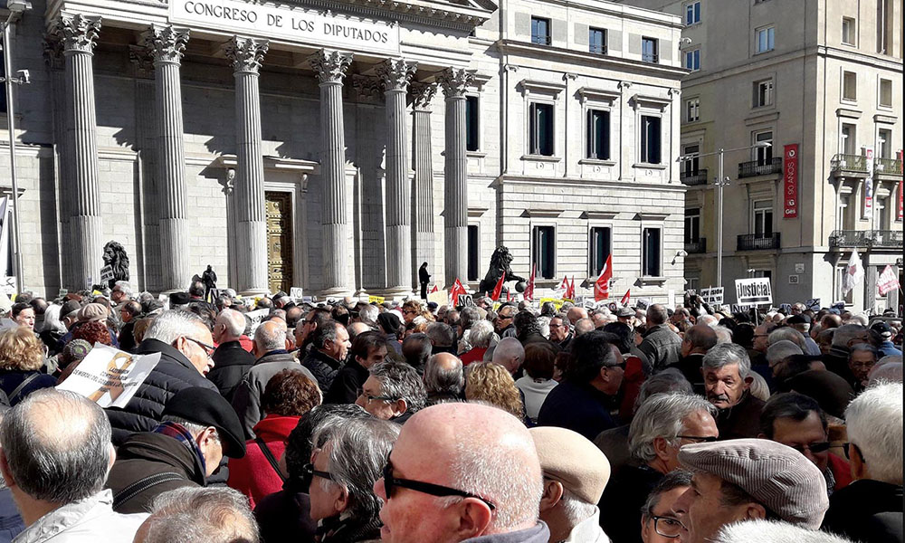 GRAF7385. MADRID, 22/02/2018.- Miles de jubilados, que secundan una concentración en defensa del sistema público de pensiones, han cortado hoy la Carrera de San Jerónimo en Madrid cerrando así el acceso al Congreso de los Diputados desde la Plaza de Neptuno hasta la calle Cedaceros. La concentración contra "las pensiones de miseria", según reza el cartel de la convocatoria ha sido organizada por la coordinadora estatal por la defensa del sistema público de pensiones, y participan en ella entre tres mil y cuatro mil personas, según algunas estimaciones policiales. EFE/Jesús Narvaiza