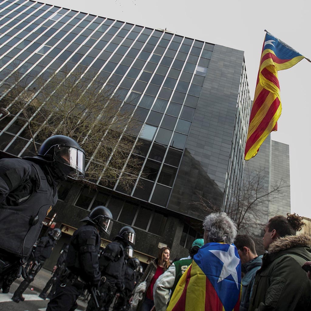 GRAF407. BARCELONA, 25/3/2018.- Miembros de los Mossos d´Esquadra impiden el paso de manifestantes en las inmediaciones de la Delegación del Gobierno en Cataluña, donde centenares de independentistas tratan de desbordar el cordón policial en protesta por la detención del expresidente catalán Carles Puigdemont. . EFE/ Enric Fontcuberta.