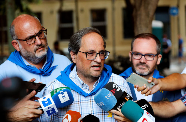El presidente de la Generalitat Quim Torra (c) atiende a los medios, acompañado por el portavoz de Jxcat Eduard Pujol (i) y Josep Costa, durante la visita que ha realizado hoy a las fiestas de Gracia, en Barcelona. EFE/Alejandro García