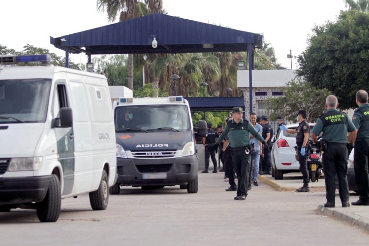 GRAF1687. MELILLA, 21/10/2018.- Efectivos de la Guardia Civil y Policía Nacional trasladan a los inmigrantes de origen subsahariano tras el salto que han realizado hoy a la valla que separa la ciudad española de Melilla, fronteriza con Marruecos, en un nuevo intento masivo de entrar de manera irregular en España. El salto se saldó con un inmigrante fallecido y un total de 25 heridos -19 subsaharianos y seis guardias civiles- según los datos facilitados por la Delegación del Gobierno en Melilla. EFE/ F.G. Guerrero