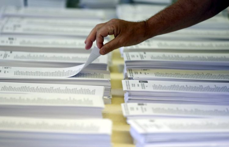A man picks up his ballot before voting in Catalonia's regional parliamentary election in Barcelona, Spain, September 27, 2015. Separatists parties are expected to win control of Catalonia's parliament in an election on Sunday, setting the region on course for a unilateral declaration of independence from Spain, which the central government says is imposible. REUTERS/Sergio Perez