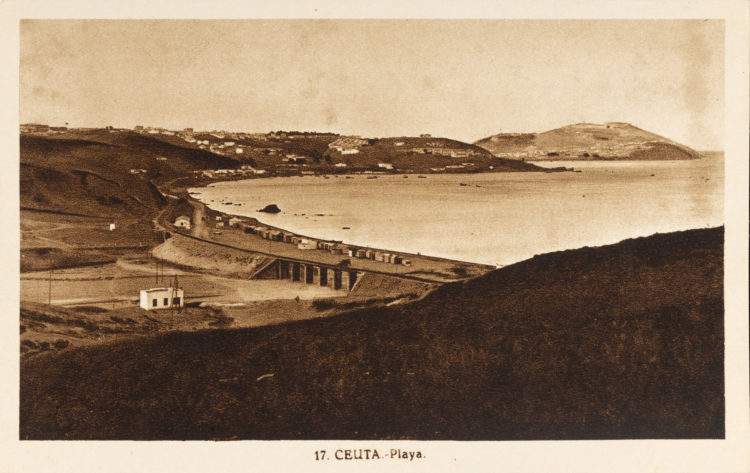 Postal nº 4458. En la zona más alejada de la Ceuta meridional, donde desemboca el Arroyo de las Bombas, nos encontramos con las playas del Tarajal. Es una pequeña ensenada que a partir de 1.918, con la construcción del ferrocarril, se fue haciendo cada vez más popular. Su máximo esplendor fue a partir de los cincuenta, con la creación de la fabrica de cervezas “Africa Star Beer”, una central térmica y un pequeño control de la policía. Un poco más tarde, la solitaria playa se llenó de “casetas playeras” que montaban los distintos estamentos militares y con ello se convirtió en nuestra familiar "Costa del Sol”, a la que se accedía con facilidad gracias a las camionetas de la linea Ceuta - Almadraba. Esta foto debe ser la primera que se hizo de esta zona, cuyo objetivo debió ser el constatar los avances habidos en el tendido de la linea férrea a Tetuán. Al mismo tiempo podemos observar los pequeños cobertizos de los trabajadores a la orilla del mar